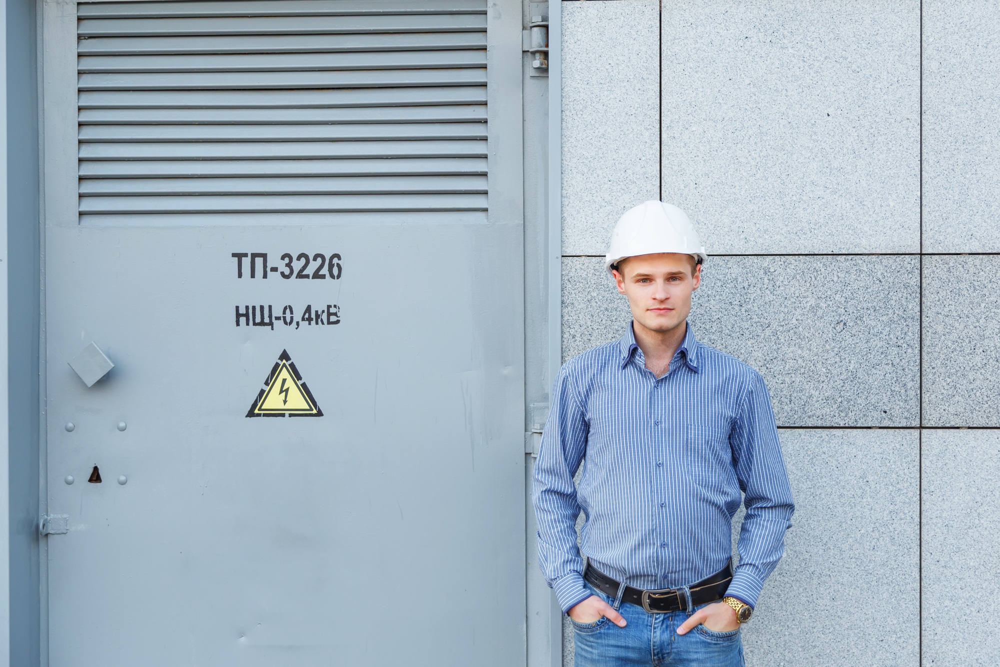 Portrait of young engineer at the transformer station
