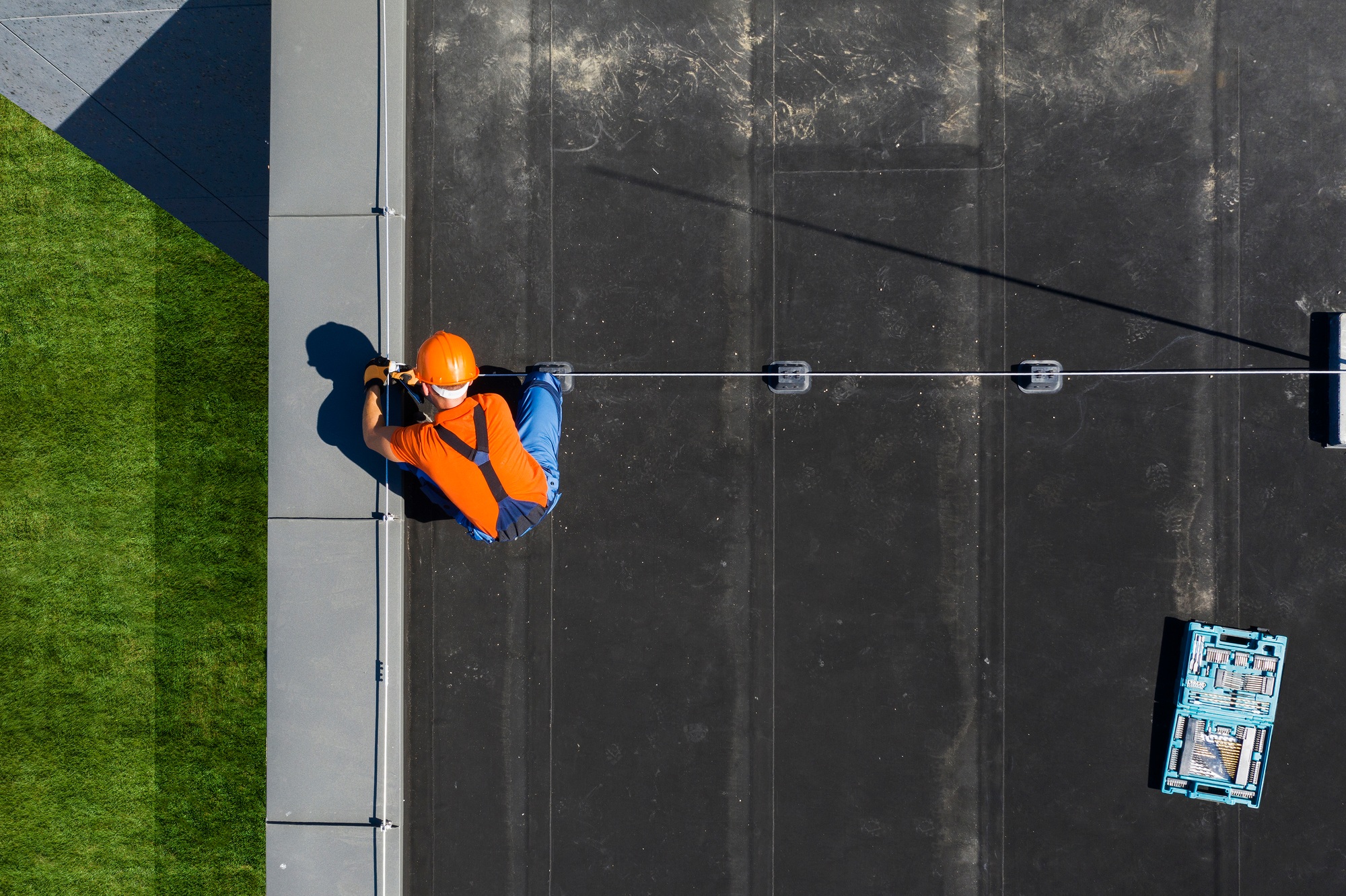 Technician Installing Lightning Protection Rod on Top of Building